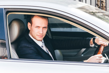 Fototapeta na wymiar Handsome businessman in suit in a car