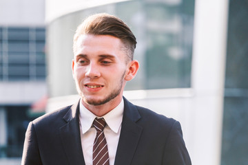 Portrait of handsome man in black suit standing outdoors
