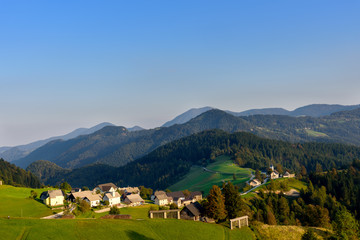 Fototapeta na wymiar Countryside village in Slovenia sunset view, idyllic rolling green hills