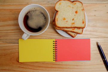 Blank notepad and coffee cup on office wooden table
