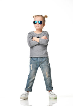 Young girl kid standing in blue aviator sunglasses happy thinking with arms crossed