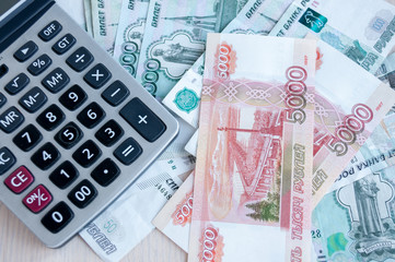 On the table there are money Russian rubles and a calculator. Calculation of profit