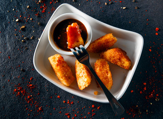 Chicken Nuggets impaled on a fork in ketchup closeup