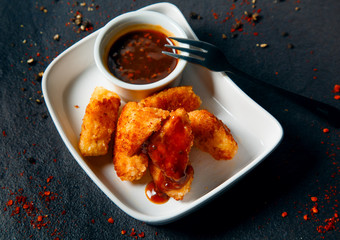 Chicken Nuggets impaled on a fork in ketchup closeup