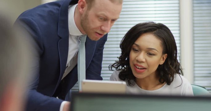 4K Business manager with tablet computer explaining to female employee in office. Slow motion.