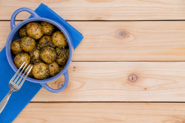 Small blue pot with seasoned baby potatoes