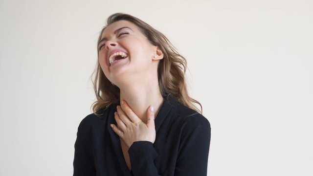Excited young woman laughing at studio