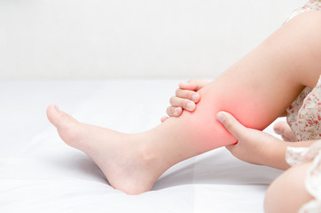Leg pain or calf muscle in a girl on bed,