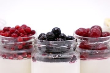 Fresh berries in the jar with the yogurt. On white background.