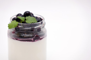 Fresh berries in the jar with the yogurt. On white background.