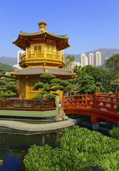 Fototapeta premium Traditional Chinese Pagoda with bridge in Chinese garden with city skyline, in Hong Kong, China