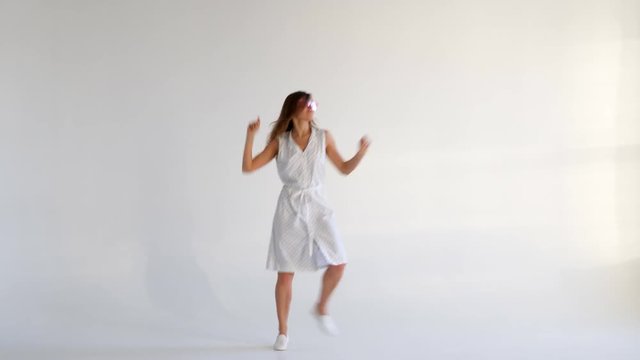 Graceful smiling girl posing while dancing on background