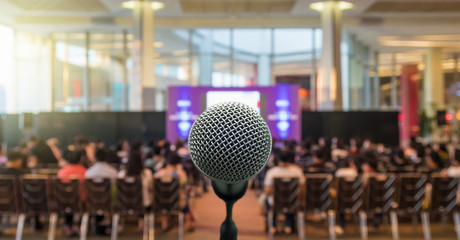 Microphone over the Abstract blurred photo of conference hall or seminar room with Speakers on the...