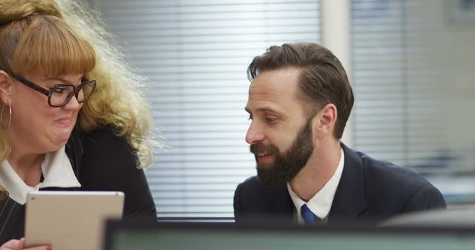 4K Funny businesswoman with tablet computer chatting & flirting with a colleague. Slow motion.