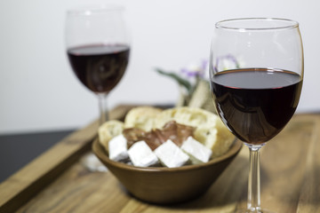 Red wine in a glass and a set of products -cheese, salami, and bread