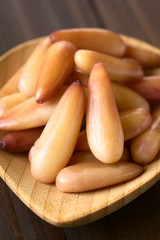 Peeled cooked Chilean pinones pine nuts eaten as snack, seeds of the Chilean pine or monkey puzzle tree (lat. Araucaria araucana) (Selective Focus one third into the image)