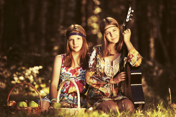 Two young fashion girls with fruit baskets in summer forest
