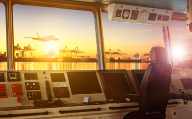 wheelhouse control board of modern industry ship approaching to harbor at night