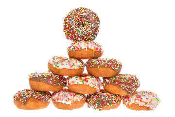 Cake donuts frosted with chocolate and vanilla frosting, rainbow candy sprinkles, stacked pyramid formation isolated on white background