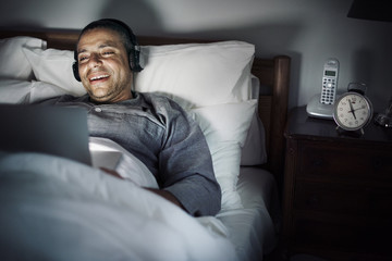 Fototapeta premium Man using laptop on a bed