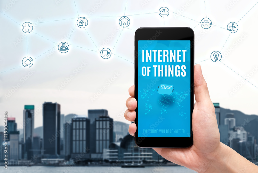 Poster hand holding mobile with internet of things (iot) word on screen with icon feature glowing in air wi