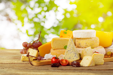 Variety of cheese types composition on wooden board