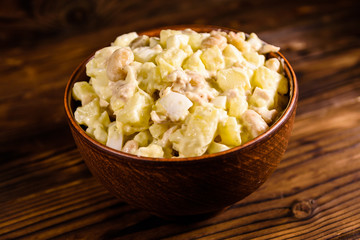 Salad with the haricot beans and meat dressed with mayonnaise in ceramic bowl