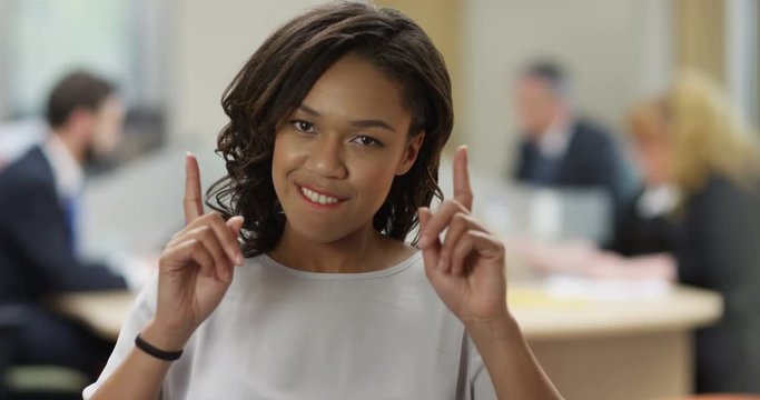 4K Portrait overly confident mixed race businesswoman giving a wry smile & gesturing to camera. Slow motion.