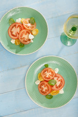 Rustic style. Italian salad tomatoes mozzarella cheese wine, top view