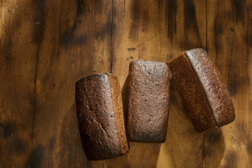Three loaf rye bread on dark wooden table