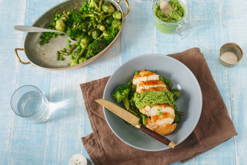 Chicken breast with fried vegetables on blue wooden table