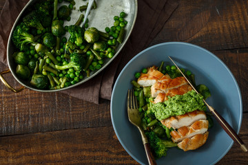 Top view chicken steak, fried vegetables on dark wooden table