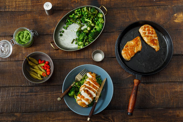 Grilled chicken breast with fried vegetables, top view. Dinner table