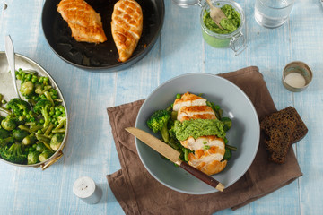 Chicken steak, fried vegetables on blue wooden table, top view