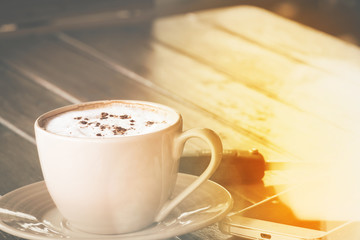 a cup of coffee on the brown wood table floor .