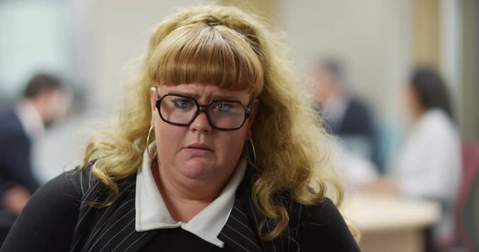4K Portrait overweight businesswoman trying not to cry with her bottom lip wobbling. Funny office concept, workplace problems. Slow motion.