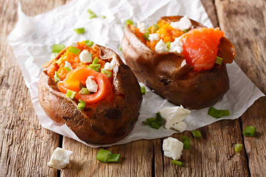Dietary food: sweet potato stuffed with salmon, feta cheese and green onions close-up. horizontal