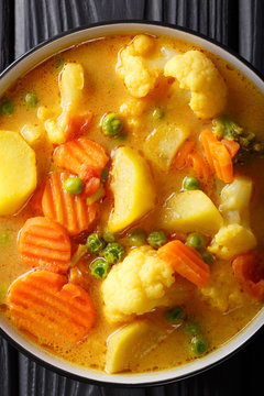 Vegetarian vegetable curry with coconut milk close-up in a bowl. Vertical top view
