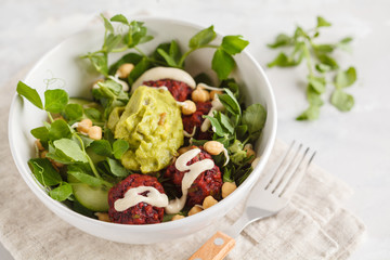 Green vegetable vegan salad with beets meatballs, Guacamole and tahini dressing. Healthy vegetarian food concept. Copy space