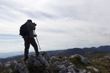 silhouette hiker take photo on mountain peak