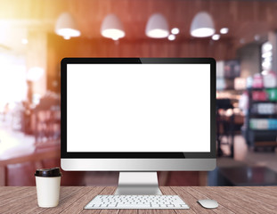 Modern Computer Monitor on a wooden desk with coffee shop background