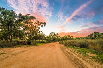 Rural Australian Landscape with colorful clouds ans dirty gravel road in Outback of Australia at...