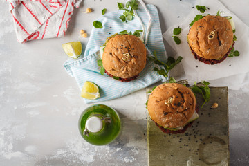 Vegan beet chickpea burgers with vegetables, Guacamole and rye bun with green smoothie. Healthy vegan food concept. Top view, copy space