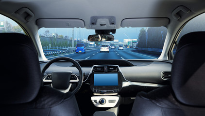 Cockpit of driverless car driving on highway viewed from rear seat.