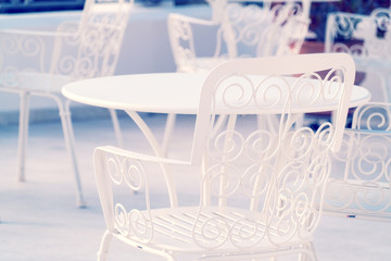 Openwork white . metal chair in the cafe