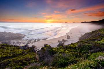 Long exposure of a colourful sunset over Brenton-on-sea main beach in South Africa