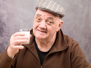 portrait homme âgé verre d'eau effervescent dans la main fond gris