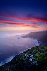 Dreamy, dramatic and colourful sunset over Storms River Mouth national park, South Africa. Long exposure with blurred water