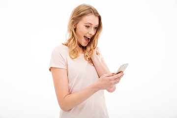 Shocked young woman using mobile phone.