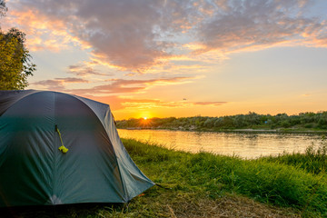 Tourist tent in a camping on the river bank